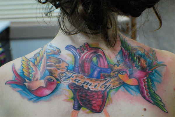  back tattoo of birds holding a banner over a heart that reads 'Family'.